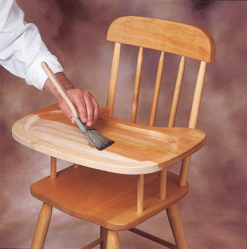 Person applying Clear SealCoat Universal Sanding Sealer for Interior Wood and Floors to wooden high chair