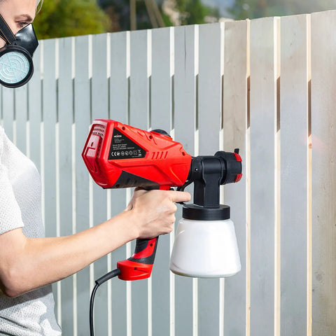 Person using Handheld HVLP Spray Gun With Adjustable Airflow And 600W Power For Home Projects Three Spray Patterns And Four Nozzles on fence