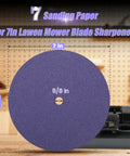 Close-up of 7-inch sanding paper for mower blade sharpener, labeled 5/8 inch, in a workshop setting with tools.