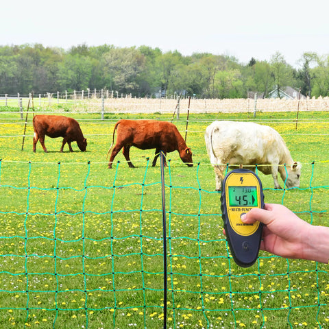 Backlit LCD Electric Fence Voltage Tester With Fault Finder, 200V To 15,000V Range, 15KV Digital Fence Tester in use with cows grazing