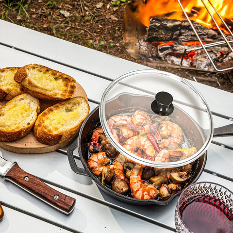 12 Inch Cast Iron Skillet With Lid Pre Seasoned Chef Pan For Indoor And Outdoor Cooking on picnic table by campfire