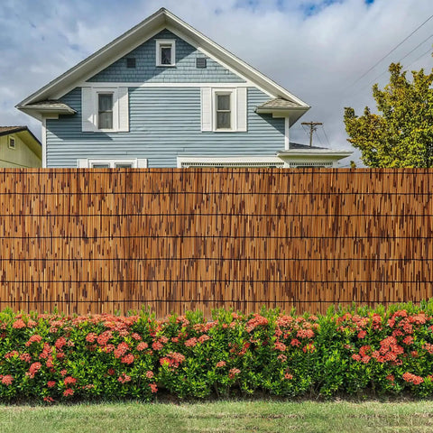 Natural Bamboo Reed Fence 6 Ft High By 16.4 Ft Long Privacy Screen for garden shown in front of a house with flowers