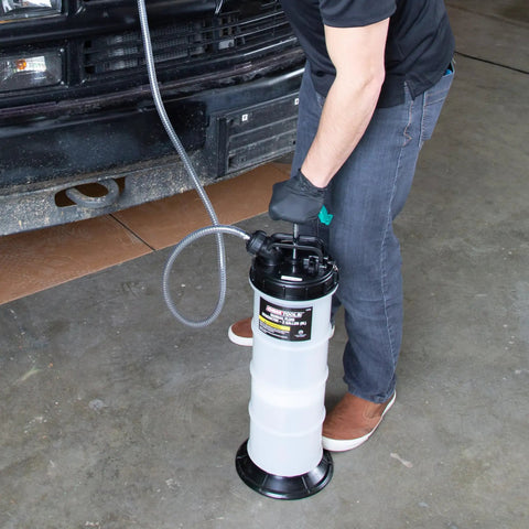 Person using Manual Fluid Extractor Pump for Oil Change and Transmission Fluid, 8L Capacity, in a garage next to a vehicle.