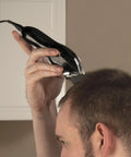Person using Deluxe Corded Clipper Pro Hair And Trim Kit with corded clipper for precise haircutting at home