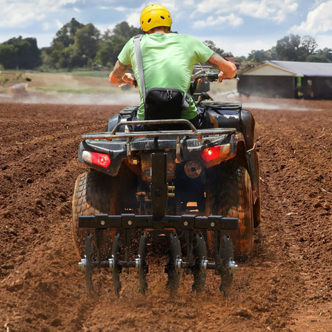 Person using 28 Inch Disc Plow Harrow With 2 Inch Receiver For ATV UTV Pull Behind Tiller Black Heavy Duty Ground Prep Tool in field