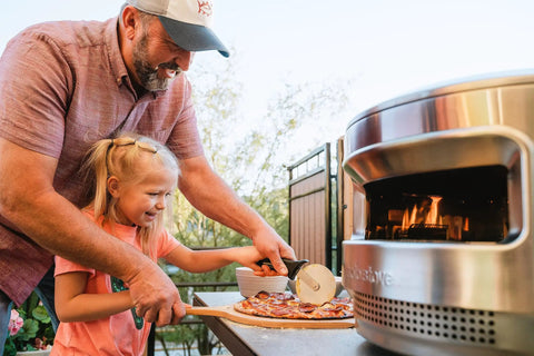 Father and daughter using Pizza Cutter Wheel With Durable 304 Stainless Steel Blade And Powder Coated Aluminum Handle Dishwasher Safe Easy Grip For Quick Slices Perfect For Sharing With Family And The Crew Pi Collection