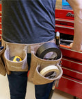 Industrial Strength Black Duct Tape For Patch Jobs And Everyday Fixes in a tool belt next to red toolbox in workshop.