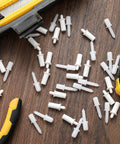 Top Shelf Spring Loaded Shutter Repair Pins Crisp White Long And Short Mix scattered on wooden surface with tools.