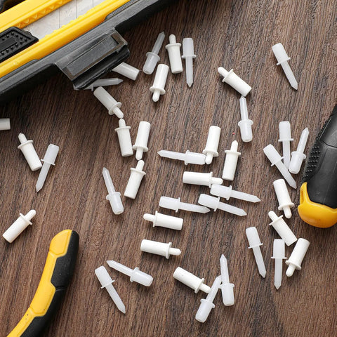 Top Shelf Spring Loaded Shutter Repair Pins Crisp White Long And Short Mix scattered on wooden surface with tools.