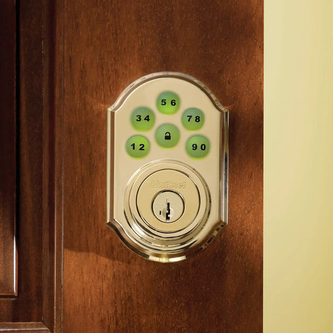 SmartCode 910 Z Wave Plus Deadbolt with Keyless Entry and Illuminated Keypad in Polished Brass Finish on Wooden Door