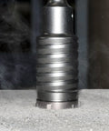 SDS-Max Hammer Core Bit 1-1/2 In By 11-3/8 In Steel drilling concrete, showing outer flute reducing friction and dust.