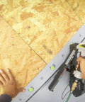 Image of Solid Grip 1 Inch Plastic Cap Staples 2000 Ct Spool being used in pneumatic stapler for housewrap installation.