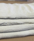 Close-up of stacked 1000 Count White Shop Towels For Auto Maintenance And Grease Cleanup, 13x14 Inch 100 Percent Cotton Rags.
