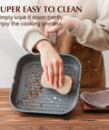 Person cleaning Nonstick Grill Pan For Stove Tops With Pour Spouts, Square 9.5 Inch Griddle, Durable Skillet on wooden surface.