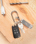 G Series SlideLock Three Dual Chamber Carabiner For Keychains And Gear holding keys and multitool on wood board