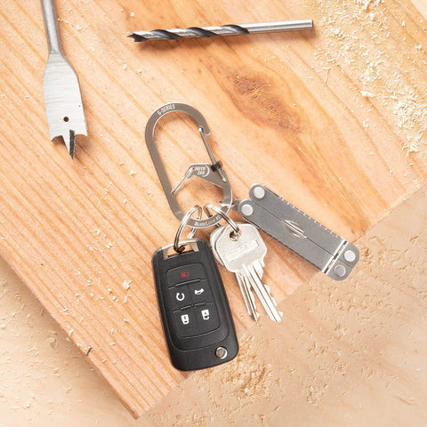 G Series SlideLock Three Dual Chamber Carabiner For Keychains And Gear holding keys and multitool on wood board