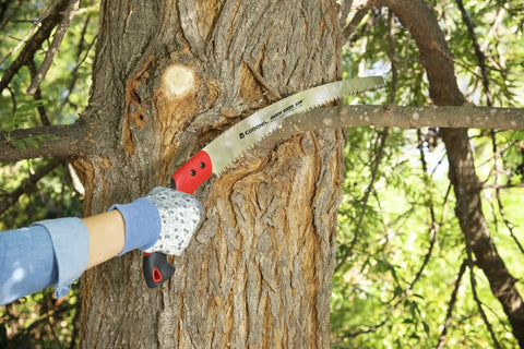RazorTOOTH Pruning Saw For One Handed Use With Curved Blade cutting tree branch, Ergonomic Pistol Grip visible