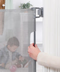 Person installing 50 Inch Wide Retractable Baby Gate For Doorways And Hallways, Mesh Safety Barrier For Babies Toddlers And Pets, Gray