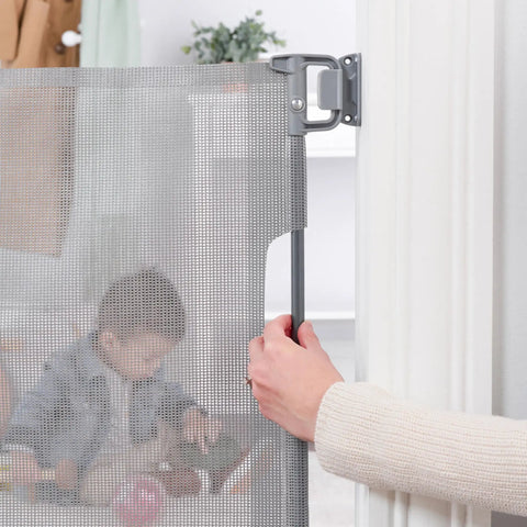 Person installing 50 Inch Wide Retractable Baby Gate For Doorways And Hallways, Mesh Safety Barrier For Babies Toddlers And Pets, Gray