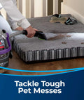 Side view of a Bissell 3-inch Tough Stain Tool attached to a carpet and upholstery cleaner, cleaning a pet bed.