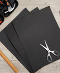 Gasket sheets top-down view; three black high-temp sheets, 15 x 11.8 in, for DIY automotive sealing on wood table