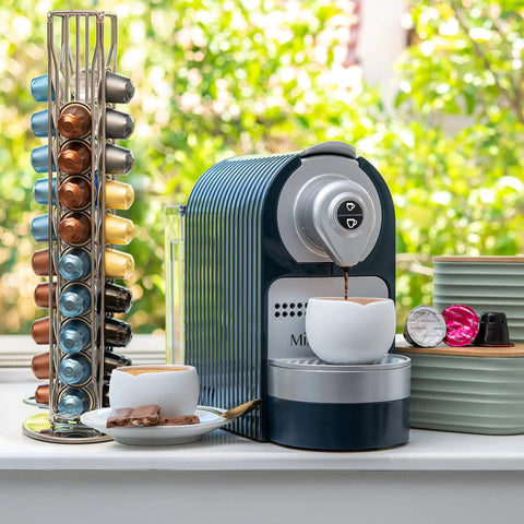 Capsule Spinning Carousel Holder For Espresso Pods next to a coffee machine on a kitchen counter.