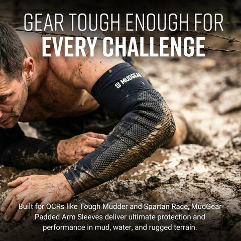 Man in mud wearing large black premium padded arm sleeves with compression elbow protection, ideal for OCR and sports.