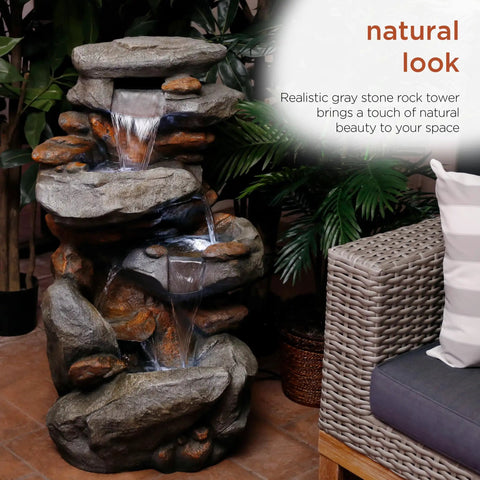 40-Inch Four Tier Rock Floor Fountain With Cascading Water And White LED Lights next to outdoor seating