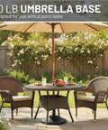 Fillable Weighted Round Umbrella Base For Patio Tables Heavy Duty Weatherproof Stand With 18 Inch Diameter And 11.5 Inch Tall Steel Stem Fits Poles From 1.5 To 2 Inches Made In USA supporting a patio umbrella in a garden setting.