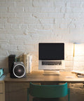 Personal Vortex Space Heater For Desk And Office on modern desktop with laptop, books, and lamp; compact and black.