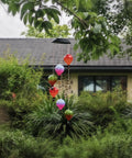 Solar Hot Air Balloon Lantern And Wind Chimes For Garden Outdoor Hanging Lights, colorful LEDs, hanging in lush garden