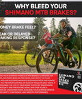 Cyclists riding mountain bikes with Shimano Hydraulic Brake Bleed Kit box display, promoting maintenance benefits.