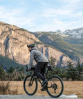 Cyclist with Waterproof Under Saddle Seat Pack For Bike Commuting And Touring, Recycled Ripstop Bag Adjusts to Saddle, Mountain Background