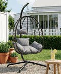Hanging Egg Chair With Stand For Indoor And Outdoor Relaxation Cozy Wicker Hammock Lounge Chair With Cushion in garden setting.