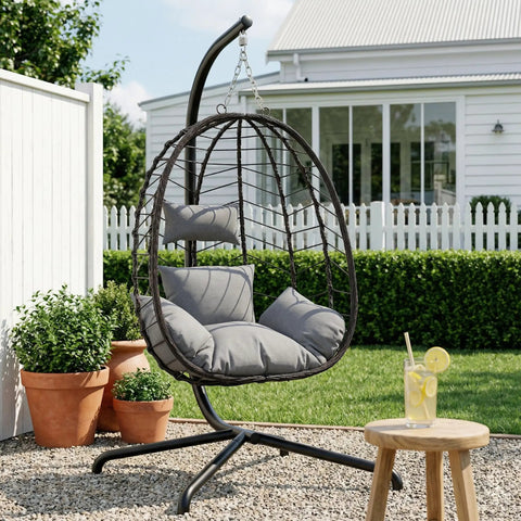 Hanging Egg Chair With Stand For Indoor And Outdoor Relaxation Cozy Wicker Hammock Lounge Chair With Cushion in garden setting.