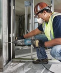 Worker using Bulldog SDS-Plus Rotary Hammer Bit 3/4 In X 6 In X 8 In Carbide-Tipped on concrete wall for fast dust removal.