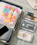 Clear Hard Shell Zipper Pouch Set of Four for Travel and Organization, showing packed toiletry, diaper, cosmetic items in suitcase.