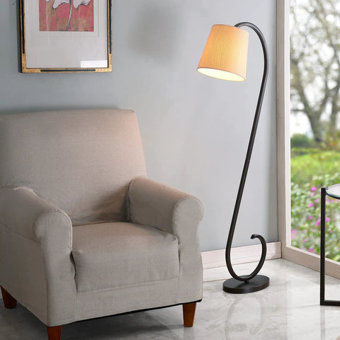 Oil Rubbed Bronze Floor Lamp With Elegant Scroll Design beside a beige armchair in a living room setting.
