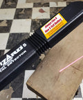 Side view of Lumber Wizard 5 metal detector, black plastic handle with yellow 9V battery warning label