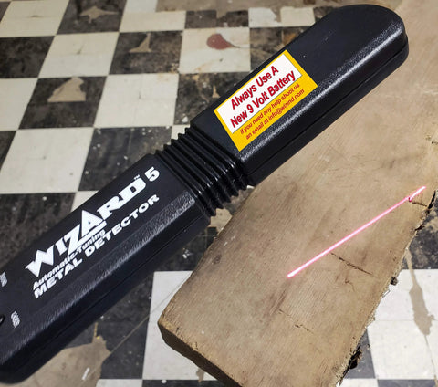 Side view of Lumber Wizard 5 metal detector, black plastic handle with yellow 9V battery warning label