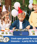 Children at a party with Break Your Own Moroccan Geodes With Crystals Inside A Hands On Fun Science Kit For Kids Includes 25 Medium 1 To 1.5 Inch Geodes 90 Percent Hollow Easy To Crack Open Educational Info And Instructions Plus Party Favors And Prizes on table with geodes.