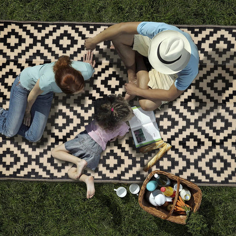 Family enjoying picnic on Waterproof Outdoor Rug 5x8 Ft Reversible Plastic Area Rug For Patio Deck Backyard RV Beach Camping Black And Beige