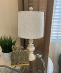 Super Cool Rustic Table Lamp Set Of Two With Vintage Farmhouse Vibes shown on nightstand, antique white resin base, linen shade.