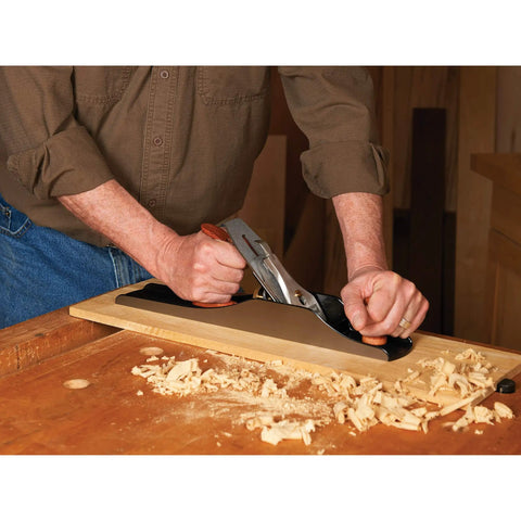 Professional Number 6 Smoothing Bench Plane Crafted From Solid Cast Iron With Precision Machined Frog And Ergonomic Bubinga Handle in use on a wooden surface.