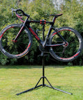 Heavy Duty Bike Repair Stand For Mountain And Road Bikes, Portable Maintenance Workstand holding a bicycle outdoors