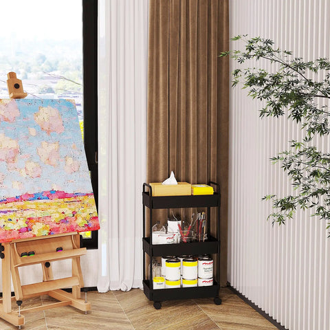 Three Tier Rolling Storage Cart With Adjustable Shelves, Mobile Utility Organizer On Wheels For Kitchen, Bath, And Laundry, Narrow Space Saver In Black Finish, positioned beside an art easel in a room corner.