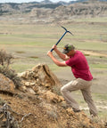 Geo Paleo Rock Pick 25 Inch USA Made Geologist Tool used for rock breaking in outdoor setting by person with red shirt.