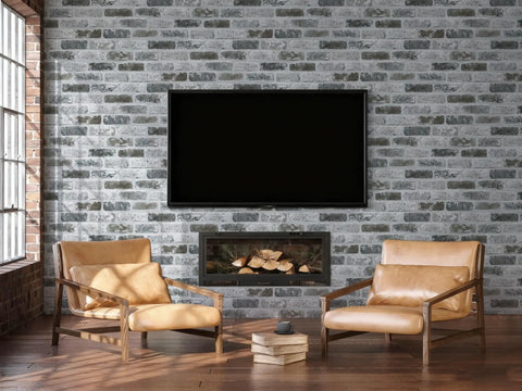 Living room with Gray Brick Peel And Stick Wallpaper With Realistic 3D Texture behind leather chairs and a TV above fireplace.