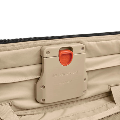 Briggs & Riley luggage latch on tan softside suitcase with orange CX Technology release