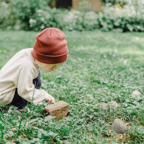 Child in garden interacting with Realistic Outdoor Fake Rock Key Hider Safe Box With Secret Compartment For Yard And Garden Large Size